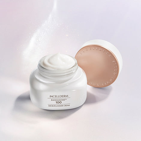 Radiansome™100 Microfluidizer Cream jar with spatula, showcasing a velvety texture against glowing, hydrated skin.