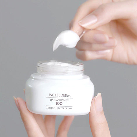 Radiansome™100 Microfluidizer Cream jar with spatula, showcasing a velvety texture against glowing, hydrated skin.