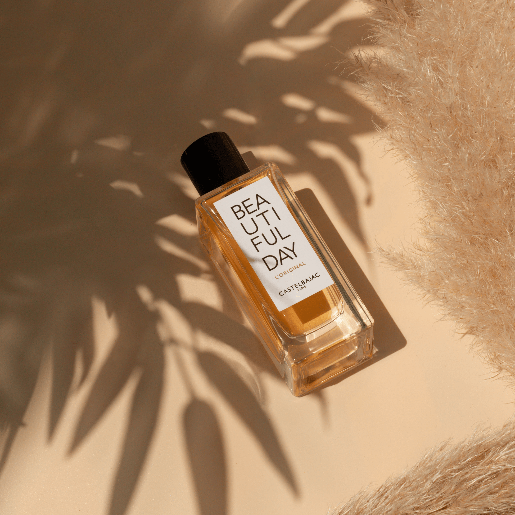 BEAUTIFUL DAY L’ORIGINAL perfume bottle with golden liquid against a minimalist backdrop, radiating modern elegance and daring femininity