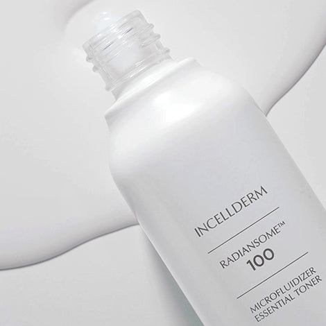 Radiansome™100 Microfluidizer Essential Toner bottle dispensing a clear liquid onto cotton pad, showcasing advanced skincare technology