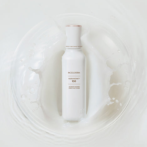 Radiansome™100 Microfluidizer Essential Toner bottle dispensing a clear liquid onto cotton pad, showcasing advanced skincare technology