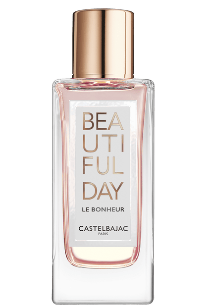 BEAUTIFUL DAY LE BONHEUR perfume bottle with golden-pink liquid, radiating vibrant energy against a sunlit, abstract backdrop