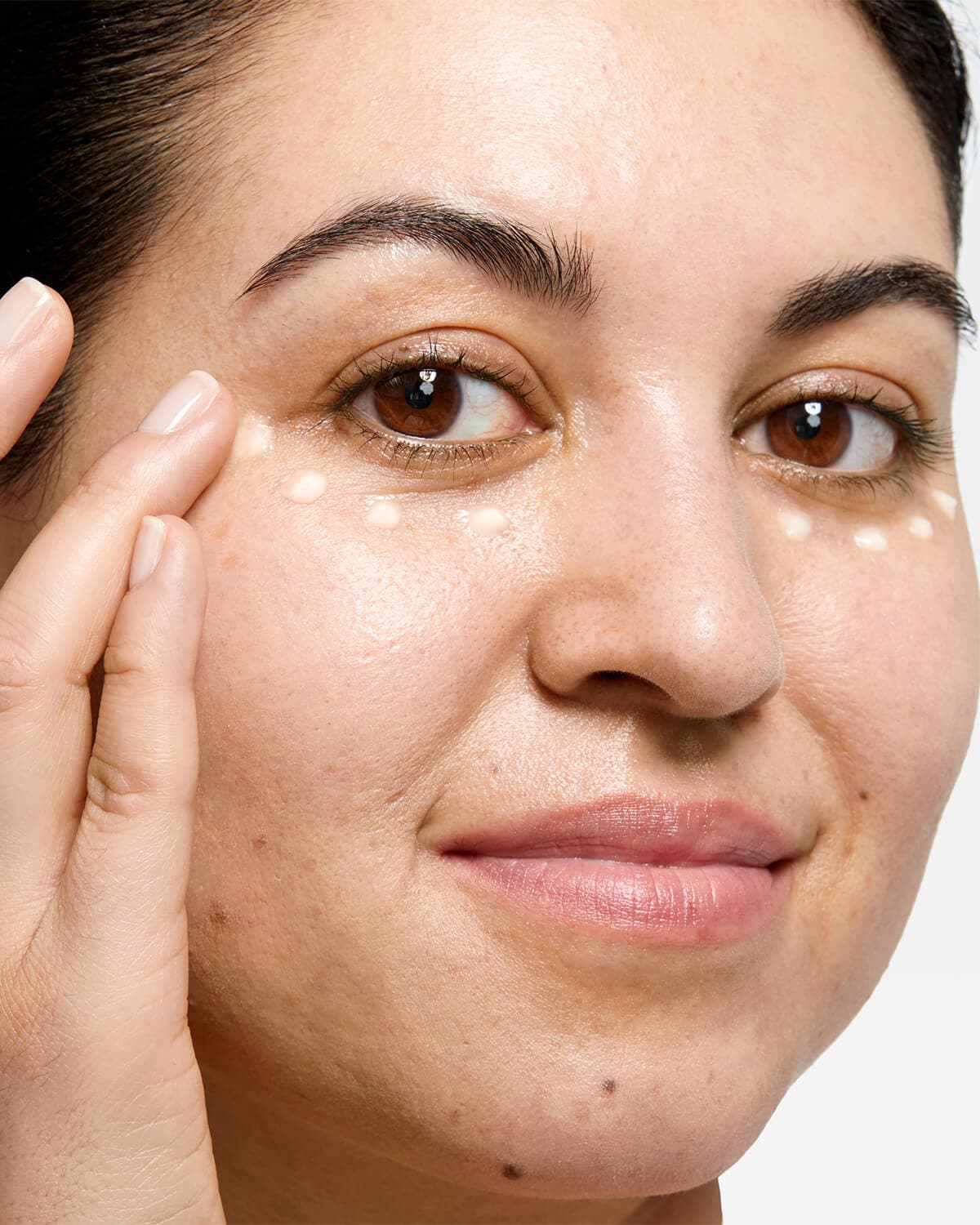 Clinique All About Eyes Rich Cream jar with cream dabbed onto a ring finger, highlighting gentle application for the delicate eye area 